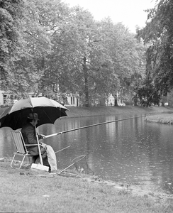 856705 Afbeelding van een vissende man aan de Stadsbuitengracht ter hoogte van de Maliesingel te Utrecht.
